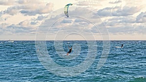 Person kitesurfing at dawn