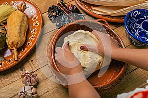 Person kneading nixtamalized corn dough to prepare tamales.