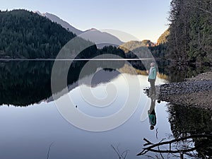 Person on lake shore reflections.