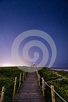 Person with lantern pointing to night sky