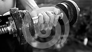 Person lifting weights with dumbbell in hand in black and white background