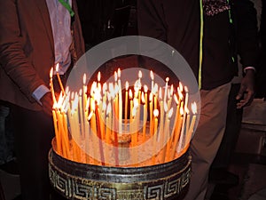 Person lighting candle in Church of the Holy Sepulchre, Jerusalem photo