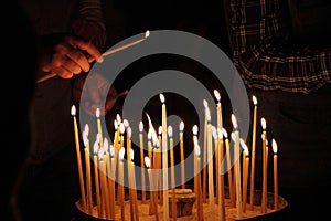Person lighting a candle to pray
