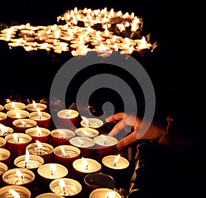 Person lights a candle during the religious ceremony