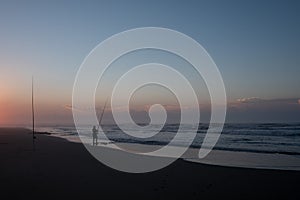 Person line fishing at Morgan Bay beach at sunset, Wild Coast, Eastern Cape, South Africa.