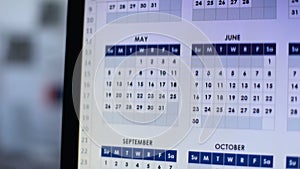 Person looking through calendar on pc, planning annual lending, installment