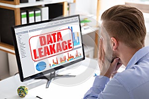 Man Looking At Computer Screen With Data Leakage Message photo