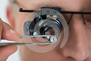 Person Looking At Diamond With Magnifying Loupe photo