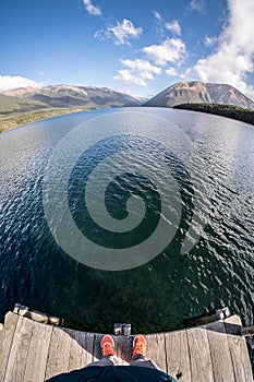 A person looking down from where he stands at lake