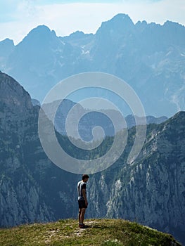 A person looking out at the dramatic and shear landscape of the Julian Alps