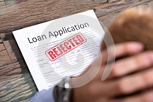 Person Looking At Rejected Loan Application photo