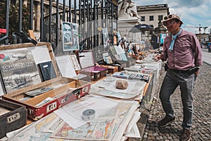 Person looking at second hand books for sale on flea market in front of the Humboldt University in Berlin