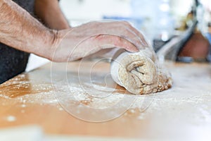 Person making bread in a home kitchen adding ingredients to make the dough and then kneading it by hand