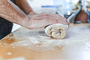 Person making bread in a home kitchen adding ingredients to make the dough and then kneading it by hand