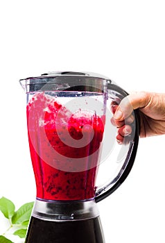Person making cherry smoothie with a blender