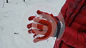 Person making snow ball and showing to camera, winter games, entertainment