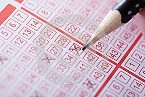 Person marking number on lottery ticket