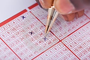 Person Marking Number On Lottery Ticket