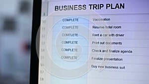 Person marking one task from online business trip plan in red color, to-do list
