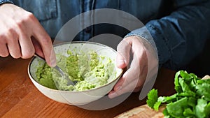 Person mashing avocado in bowl