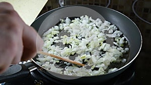 Person mixes chopped onion and garlic