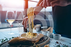 person mixing suluguni cheese and egg yolk in georgian adjarian khachapuri