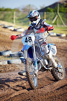 Person, motorcycle and dirt race track adventure as .professional in action, danger or fearless risk. Bike rider, off