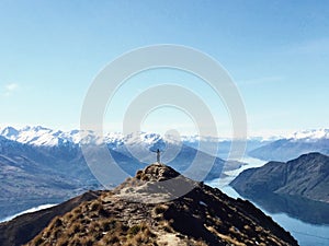 Person on Mountain Peak Overlooking the Lake With Open Arms