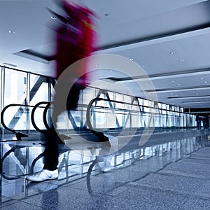 Person move in grey corridor with escalators