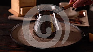 Person moving a coffee pot in circles on sand
