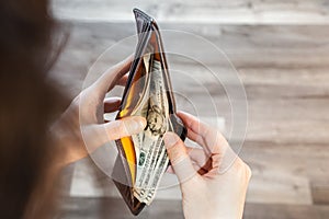 Person open wallet with 20 dollar banknotes inside