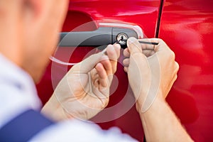 Person Opening Car Door With Lockpicker