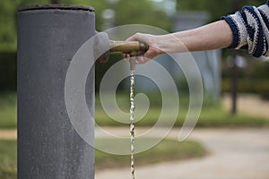 Person opens the tap of the water fountain