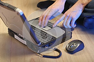 a person operates an old laptop on a touchpad