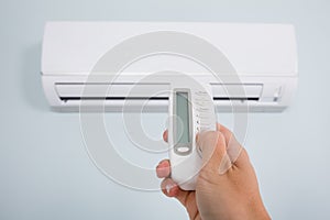Person Operating Air Conditioner With Remote Control