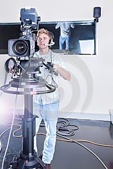 Person operating a studio camera and ready to shoot