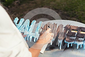 Person painting polystyrene letters with brown paint in spray photo