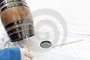 Person paints the metal hoops of the wooden barrel