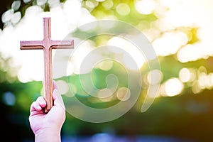 Person palm hands to hold holy cross, crucifix to worship.