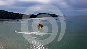 A person on a parasail, cruise liners and speedboats share the scene on Patong Bay in Patong, Thailand
