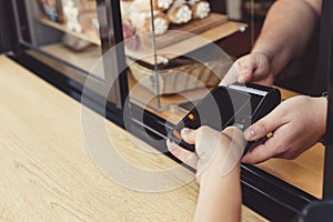 Person paying pay through smartphone using NFC