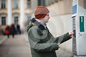 A person pays for parking in a parking lot. A bank card fee for parking.