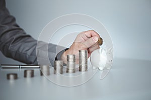 Person with pile of coins and piggy bank, money saving concept for future use and financial stability, salary management, personal