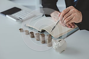Person with pile of coins and piggy bank, money saving concept for future use and financial stability, salary management, personal
