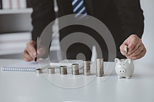 Person with pile of coins and piggy bank, money saving concept for future use and financial stability, salary management, personal