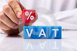 Person Placing Red Percentage Block Over Vat