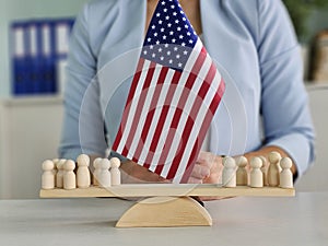 A person placing a wooden flag in front of small figures representing a community gathering photo