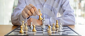 Person playing chess board game, business man concept image holding chess pieces like business competition and risk management,