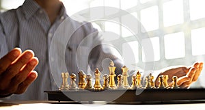 Person playing chess board game, business man concept image holding chess pieces like business competition and risk management,