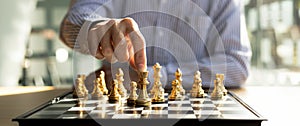 Person playing chess board game, business man concept image holding chess pieces like business competition and risk management,
